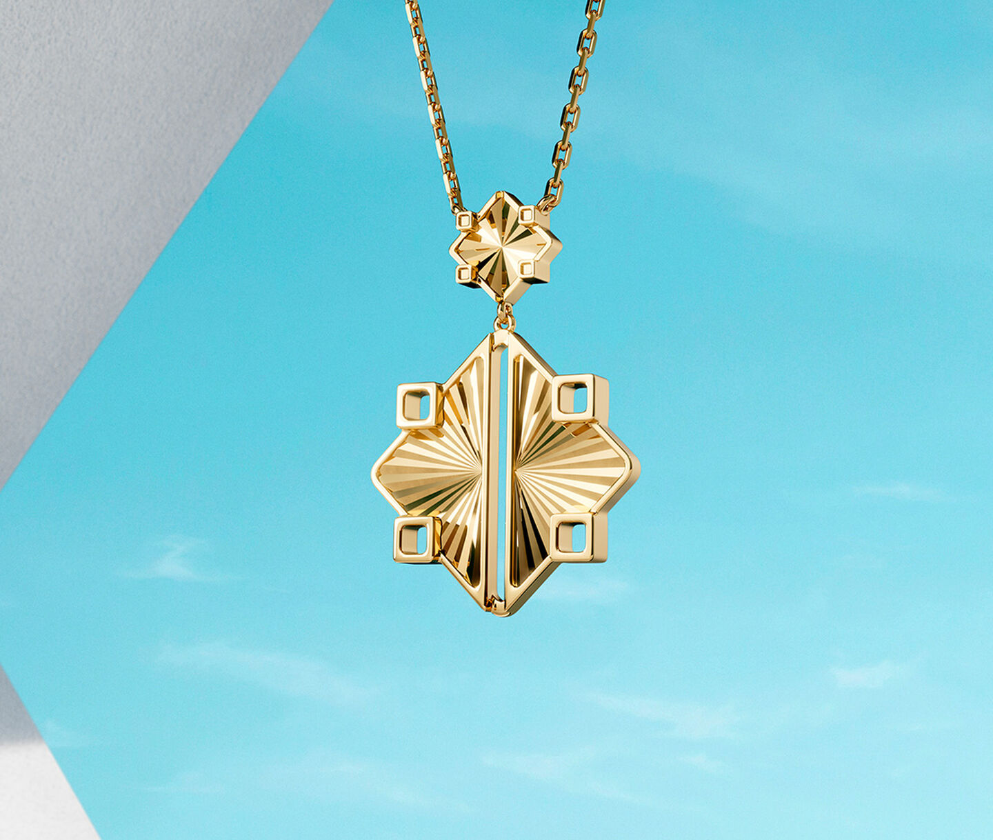 Birks Muse yellow gold drop necklace on a sky background.